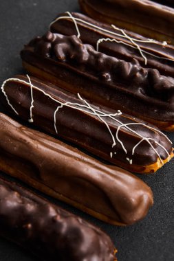 Siyah arka planda çikolata tüpleri. Farklı renkte tatlı dolgulu tüpler. Tatlılar konsepti