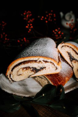 Delightful Poppy Roll and Strudel Displayed on a Festive New Year's Table Surrounded by Holiday Decorations clipart