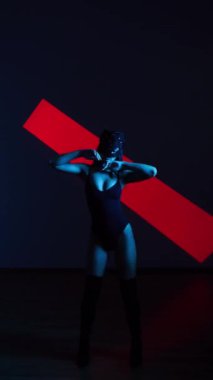 Neon ışıkta poz veren BDSM maskeli seksi kadın. BDSM konsepti. Sevgililer Günü. Kedi Kadın. Dikey video