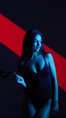 Neon ışıkta poz veren BDSM maskeli seksi kadın. BDSM konsepti. Sevgililer Günü. Kedi Kadın. Dikey video