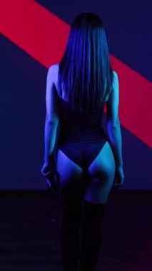 Neon ışıkta poz veren BDSM maskeli seksi kadın. BDSM konsepti. Sevgililer Günü. Kedi Kadın. Dikey video