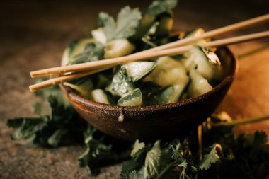 Pickled Cucumbers Served on a Rustic Plate With Fresh Parsley and Herbs, Enhanced by Sushi Sticks for a Delightful Culinary Experience clipart