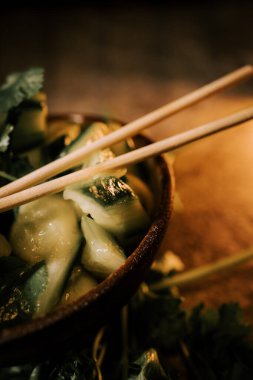 Pickled Cucumbers Served on a Rustic Plate With Fresh Parsley and Herbs, Enhanced by Sushi Sticks for a Delightful Culinary Experience clipart