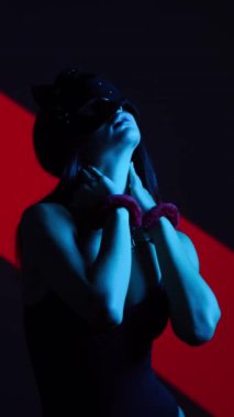 Kelepçeli Kedi Maskeli Seksi Kadın BDSM Biçimlendirmesini Canlı Bir Neon Arkaplan Karşısında Gösteriyor