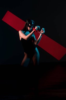 Ellerinde kelepçe olan kedi maskeli bir kadın. Vücut giysili seksi bir kadının portresi. BDSM konsepti. Sevgililer Günü.