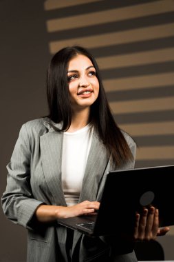 Young business woman working with laptop in modern office during daytime.Online work concept.Portrait of office worker.Woman with laptop clipart