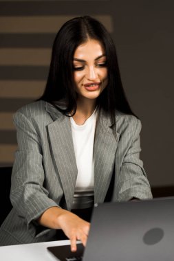 Young business woman working with laptop in modern office during daytime.Online work concept.Portrait of office worker.Woman with laptop clipart