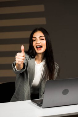 Young business woman working with laptop in modern office during daytime.Online work concept.Portrait of office worker.Woman with laptop clipart