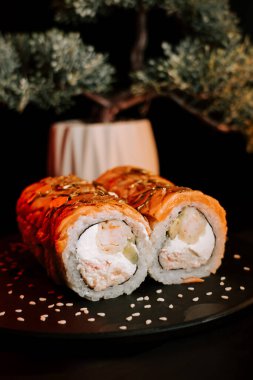 Zıt Renkler ve Dokularla Zarif Koyu Yüzeyde Taze Suşi Yuvarlamaları Gösterildi