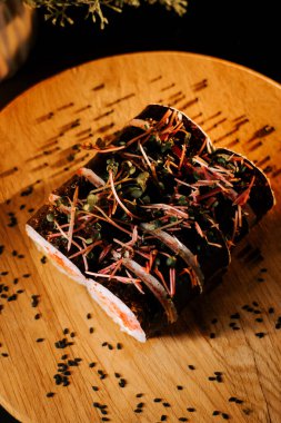 Ahşap bir tahtanın üzerinde deniz ürünleri ve otlarla dolu taze rulo ve dağınık eşlenik. Suşi konsepti. Japon mutfağı kavramı