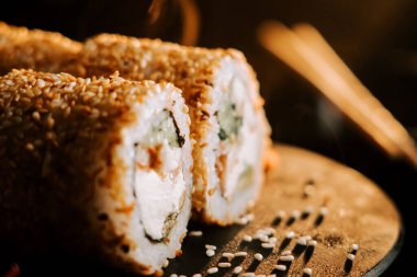 Siyah arka planda susamlı ve zencefilli taze suşi. Suşi konsepti