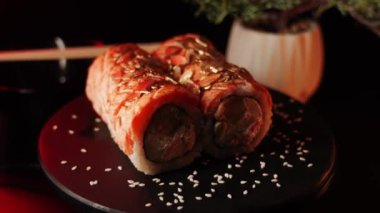 Suşi siyah arka planda bir tahtada döner. Suşi konsepti. Siyah arka planda taze rulo. 4k