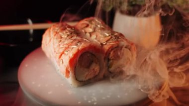 Suşi siyah arka planda bir tahtada döner. Suşi konsepti. Siyah arka planda taze rulo. 4k
