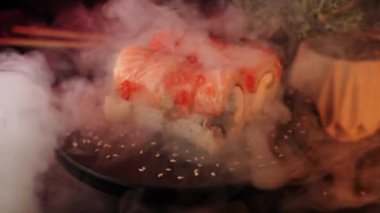 Suşi siyah arka planda bir tahtada döner. Suşi konsepti. Siyah arka planda taze rulo. 4k