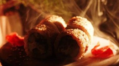 Suşi siyah arka planda döner. Lezzetli Japon suşisi hazır ve nazır. Taze unagi suşi ve somon ve Philadelphia peynirli rulo..