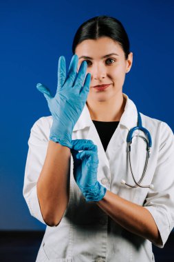 Portrait of a woman pediatric doctor in a white coat with a stethoscope against a blue background showcasing her dedication to children's health