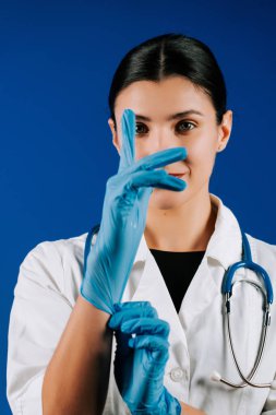 Portrait of a woman pediatric doctor in a white coat with a stethoscope against a blue background showcasing her dedication to children's health clipart