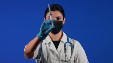 Kadın doktor elinde şırınga tutuyor. Bir sağlık çalışanının portresi. Aşı konsepti.