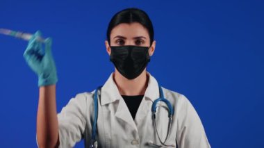 Kadın doktor elinde şırınga tutuyor. Bir sağlık çalışanının portresi. Aşı konsepti.