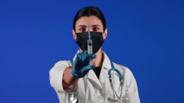 Kadın doktor elinde şırınga tutuyor. Bir sağlık çalışanının portresi. Aşı konsepti.