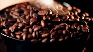 Kahve çekirdeklerinin yakın plan görüntüsü yüksek çözünürlüklü siyah arka planda zengin dokular sergiliyor.