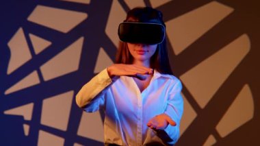 Kadın, canlı bir dijital ortamda sanal gerçeklik gözlüğü takarken büyüleyici bir teknolojiyle meşgul oluyor.