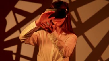 Kadın, canlı bir dijital ortamda sanal gerçeklik gözlüğü takarken büyüleyici bir teknolojiyle meşgul oluyor.