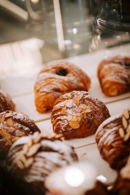 Sabahın köründe sıcak bir kahve dükkanının tezgahında taze pişmiş kruvasanlar sergileniyor.