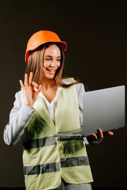 Güvenilir kadın mühendis, karanlık bir arka planda dizüstü bilgisayarıyla çatışmaya giriyor.