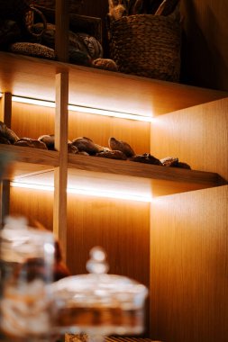 Konforlu bir mağazadaki ahşap raflarda sergilenen taze pişmiş ekmek.