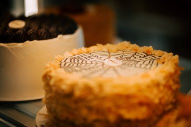 Delicious cakes displayed in a pastry shop showcasing a variety of flavors during a bustling afternoon clipart