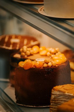 Delicious cakes displayed in a pastry shop showcasing a variety of flavors during a bustling afternoon clipart