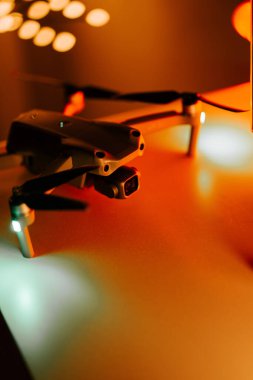Bir akşam kurulumu sırasında arka planda sıcak bokeh ışıkları olan bir masadaki İHA 'nın yakın plan görüntüsü