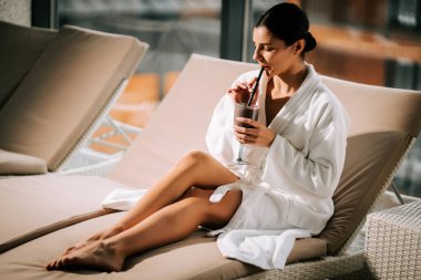 Kokteylle kaplıcada dinlenen bir kadın huzur ve gençliğin tadını çıkarıyor.