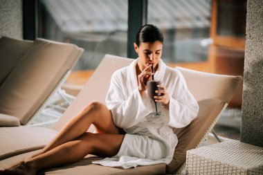 Kokteylle kaplıcada dinlenen bir kadın huzur ve gençliğin tadını çıkarıyor.