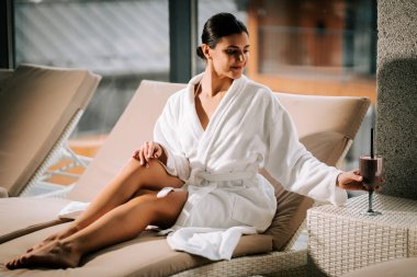 Kokteylle kaplıcada dinlenen bir kadın huzur ve gençliğin tadını çıkarıyor.