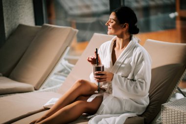 Kokteylle kaplıcada dinlenen bir kadın huzur ve gençliğin tadını çıkarıyor.