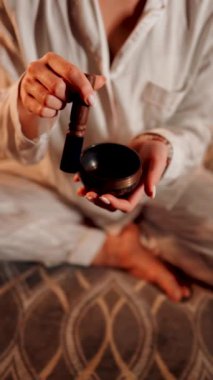 Tibet şarkı kasesi ile meditasyon yapan bir kadın huzur ve rahatlama ortamında dinlenme ve farkındalık için