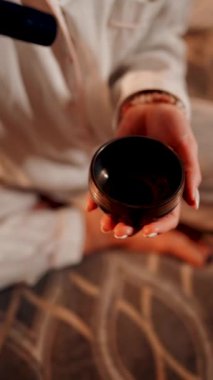 Tibet şarkı kasesi ile meditasyon yapan bir kadın huzur ve rahatlama ortamında dinlenme ve farkındalık için