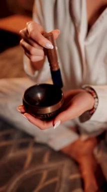 Tibet şarkı kasesi ile meditasyon yapan bir kadın huzur ve rahatlama ortamında dinlenme ve farkındalık için