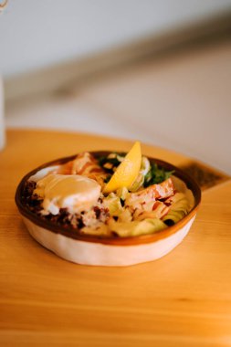 Lezzetli somon kasesi, kırmızı pirinç, avokado ve ev yapımı Sezar soslu haşlanmış yumurta.