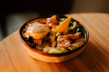 Lezzetli somon kasesi, kırmızı pirinç, avokado ve ev yapımı Sezar soslu haşlanmış yumurta.