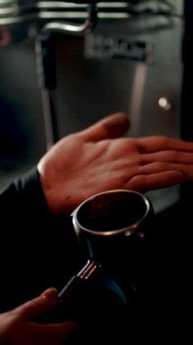 Barista sabahları yoğun bir kafede kahve makinesiyle kahve hazırlar.