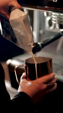 Barista sabahları yoğun bir kafede kahve makinesiyle kahve hazırlar.
