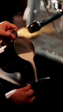 Barista sabahları yoğun bir kafede kahve makinesiyle kahve hazırlar.