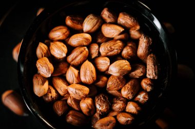 Siyah bir tabağa dizilmiş fındıklar ve zıt bir arka plan.