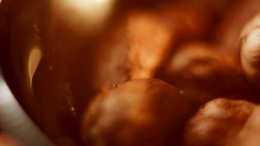 Fındıklar, doğal güzelliklerini ve dokularını sergileyerek, rahat bir ortamda bir tabakta yuvarlanıyor ve dönüyorlar.