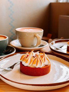 Sabah saatlerinde rahat bir kafede, ahşap bir masada servis edilen iki fincan latte.