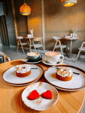 Sıcak bir öğleden sonra sıcacık bir kafede lezzetli bir tatlı ve kahvenin tadını çıkardılar.