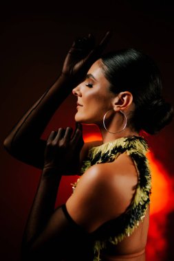 Şehvetli Latin dansçı dumanlı atmosferde dramatik ışıklandırma ile Latin dansına olan tutkusunu ve yeteneğini gösteriyor.